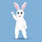 White anthropomorphic Easter hare on blue background waving his paw