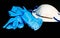 White antivirus mask and blue latex gloves on dark background