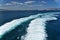 A white arc on the Mediterranean Sea behind a ship sailing from the port of Ceuta.Marocco, Africa.