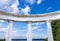 White arch with doric columns against blue sky