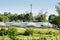 White arched greenhouses for growing vegetables and salads against the background of a blue sky and a mobile phone