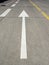 White arrow on the asphalt, broken white and yellow lines. Painted road marking markings. Road marking background. Traffic sign