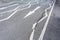 White arrow on cracked asphalt surface road.