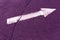 White arrow on purple asphalt surface.