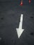 White arrow on the road and orange cone