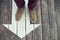 White arrow sign on wooden floor. Man`s legs standing on arrow sign painted on the floor. Direction sign background