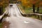 White arrow signs on the road with wooden guardrails