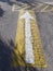 White arrow on a yellow background on cracked road tarmac