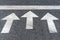 White arrows on black highway asphalt, pedestrian crossing road marking fragment