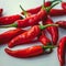 White background adorned with a close up of fiery red peppers