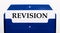 On a white background, a blue folder for papers. In the folder is a sheet of paper with the word REVISION