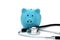 On a white background is a blue piggy bank and a stethoscope.