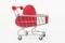 On a white background close-up of a supermarket cart with a red wooden heart. Shopping concept, love of shopping, love