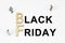 On a white background, figures of businessmen, wooden letters and the inscription - BLACK FRIDAY