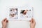 on white background, hands flip through photobook from home family photo shoot