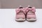 On a white background pink baby female sneakers, copy space