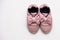 On a white background pink baby female sneakers, copy space