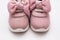 On a white background pink baby female sneakers, copy space