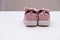 On a white background pink baby female sneakers, copy space