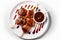 On a white background, there is a plate with delectable chicken lollipops with sauce