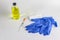 on white background. two blue gloves. the syringe is very small. bubble with yellow liquid