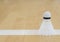 White badminton shuttlecock on a line hall floor at badminton courts
