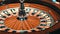 White ball stopped in rotating casino roulette. Close up wooden roulette wheel