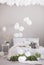 White balloons under the ceiling of grey scandinavian bedroom with double bed and green plants in pots, real photo with copy space