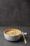 White bamboo plate bowl with egg noodles and chopsticks on a dark marble slate background