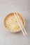 White bamboo plate bowl with egg noodles and chopsticks on a light background