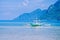 White banca boat in calm blue ocean, Seven Commandos Beach in background, El Nido, Philippines