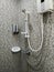 White bath hand shower fixture on the colorful warmtone wall with other items in modern bathroom
