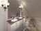 White bath sink with large mirror and sconces on the sides of th