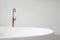 White bathtub with copper faucet in contemporary interior design
