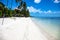 White beach and blue sea tropic landscape. Tropical nature with palm trees. Empty beach with coral sand and palm