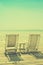 white beach chair facing seascape with vintage filtered image