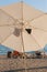 White beach umbrella on summer coast. Sea beach with sun umbrella is waiting for tourists on Sunset.