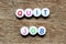 White bead with letter in word quit job on wood background