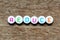 White bead with letter in word reduce, on wood background