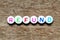 White bead with letter in word refund on wood background