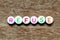 White bead with letter in word refuse on wood background