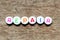 White bead with letter in word repair on wood background