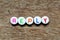 White bead with letter in word reply on wood background