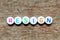 White bead with letter in word on resign wood background