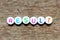 White bead with letter in word result on wood background