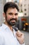 White bearded man smiling at camera while standing at city street