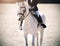 White beautiful pony with baby-rider in the saddle