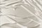 White beautiful satin fabric draped with soft folds, silk cloth background, close-up, copy space