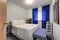 White bedroom features blue floor length window curtains