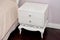 White bedside table in a bedroom